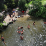Enfants sautant depuis le pont à l'entrée de Whakarewarewa